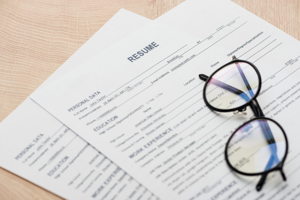 Resume laying on desk with glasses sitting on top.