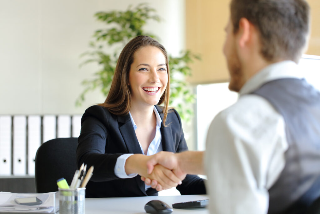 Business woman shaking hands with a man accepting a job offer.