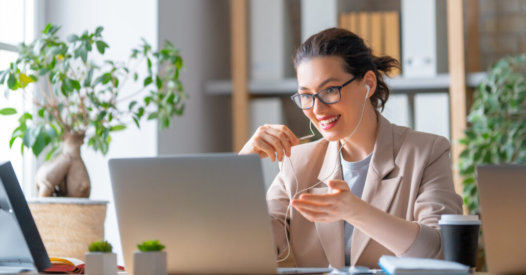 Woman in front of laptop talking to someone from a cover letter writing service.