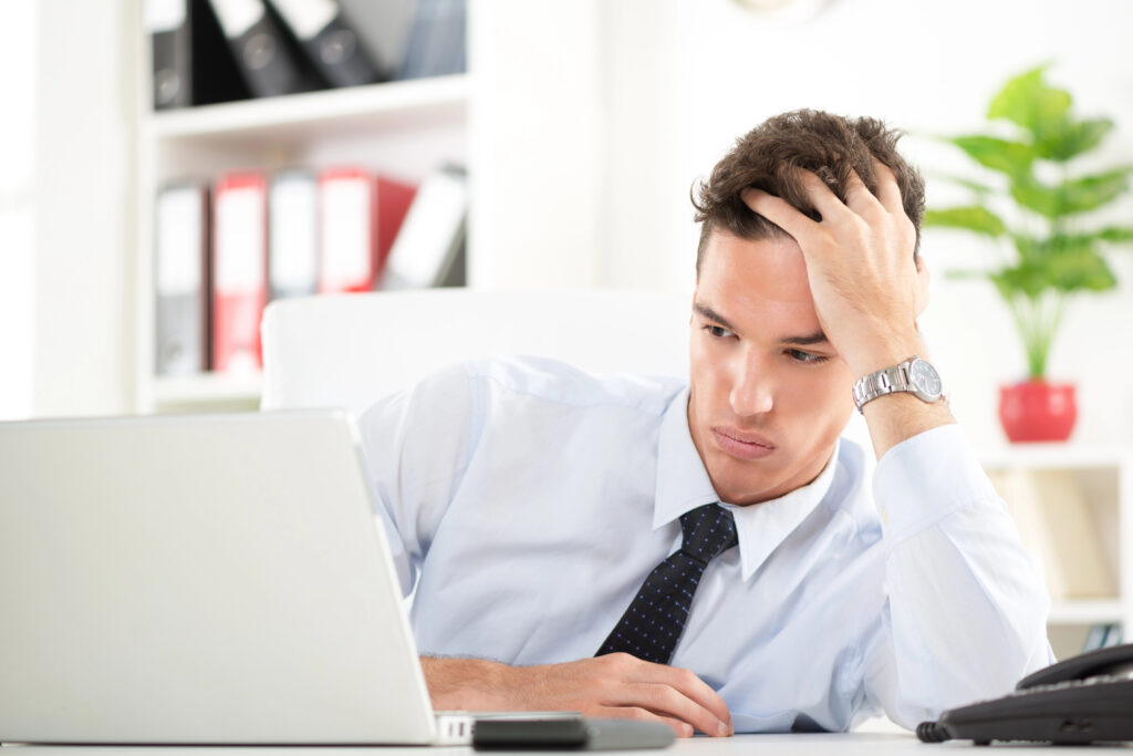 frustrated man looking at his laptop