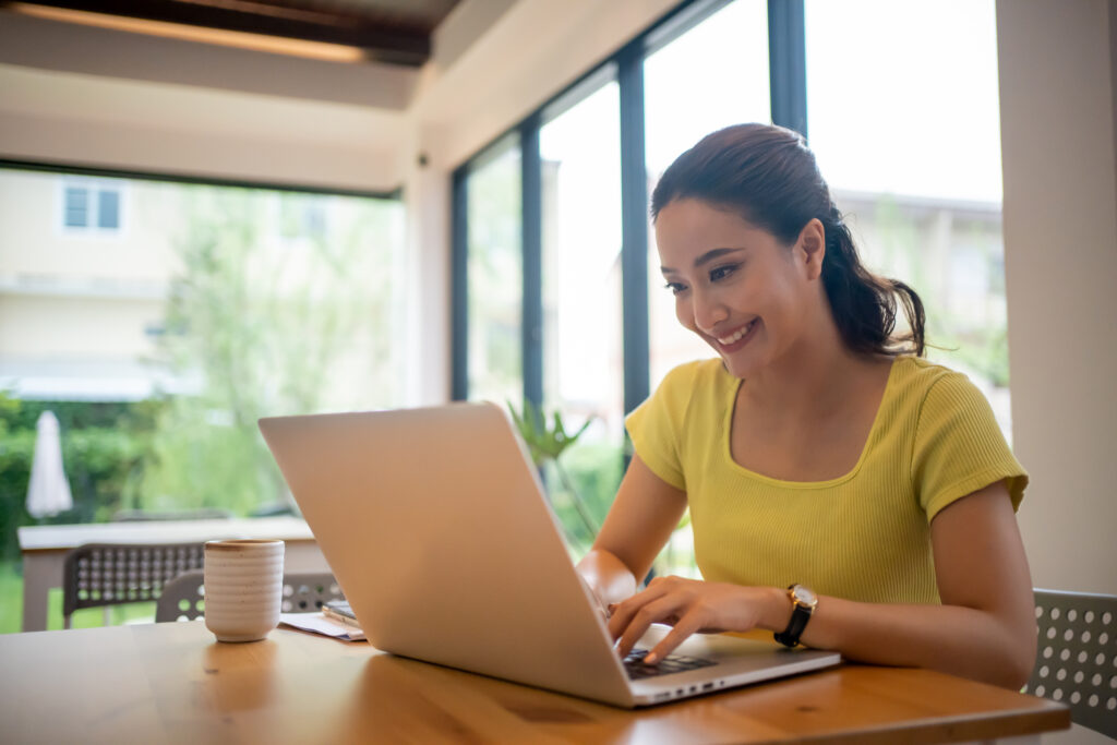 Woman looking at key questions to ask at the end of an interview on her laptop.