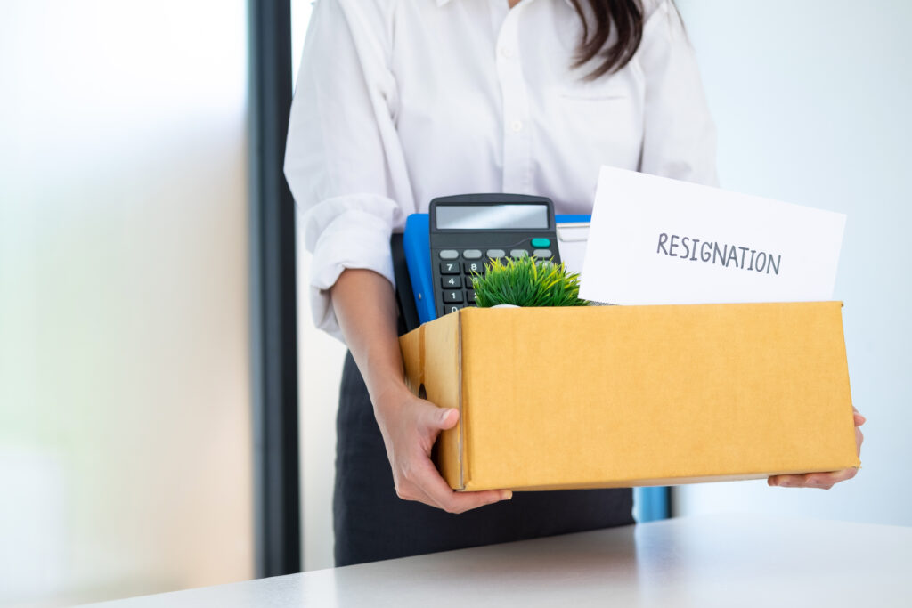 Woman carrying box with resignation letter after she figured out how to quit a job.