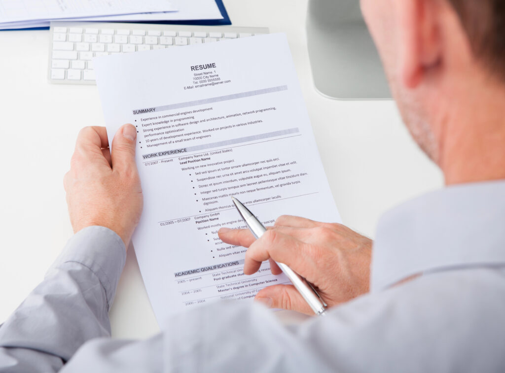 View from over the shoulder of a male resume consultant reviewing resume.