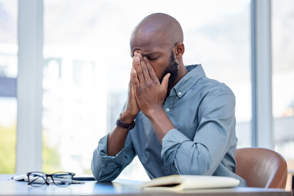 Man with head in hands wondering how to quit a job