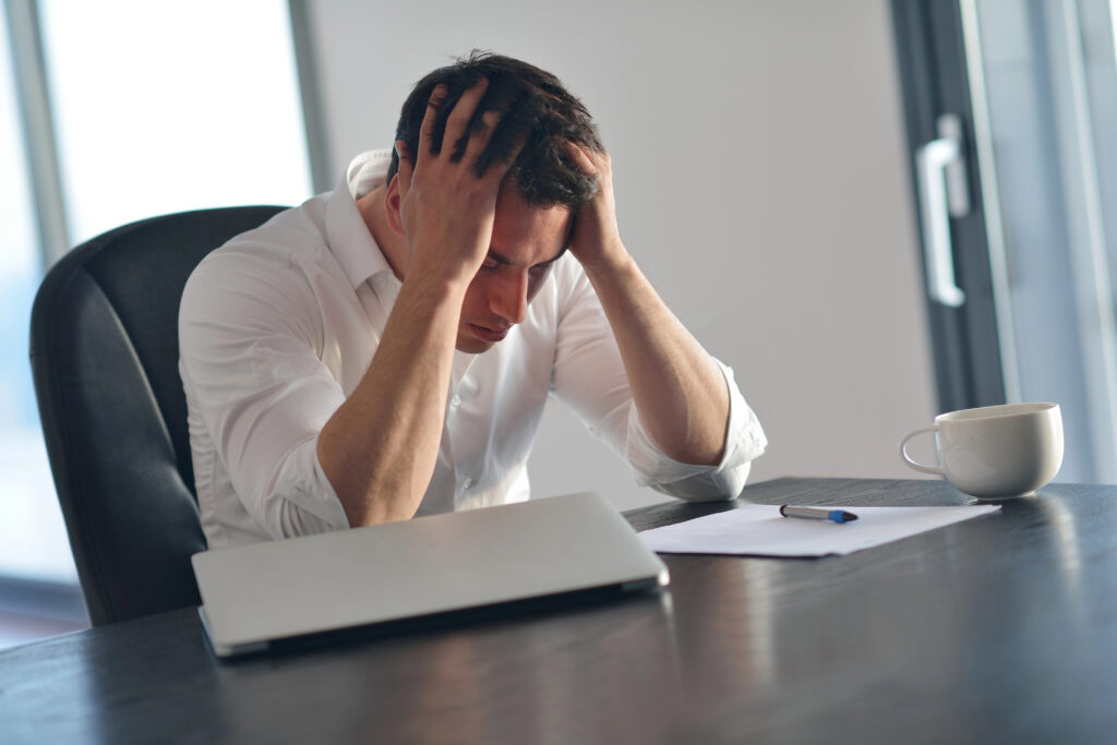 frustrated businessman with head in his hands