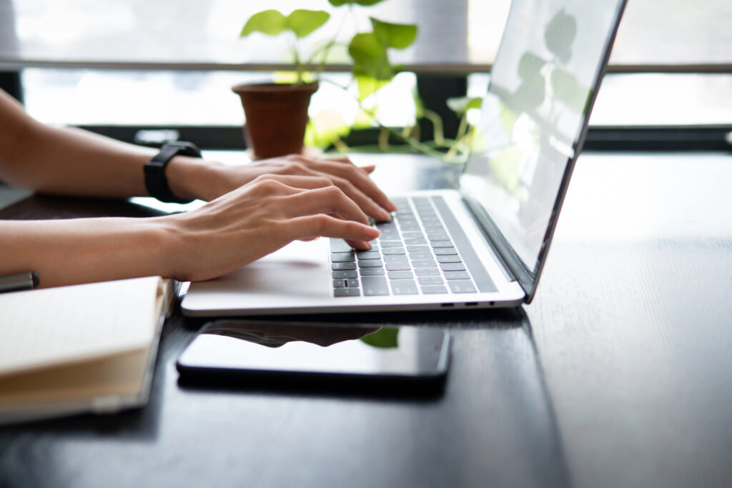 A person accepting a job offer while typing on a laptop.