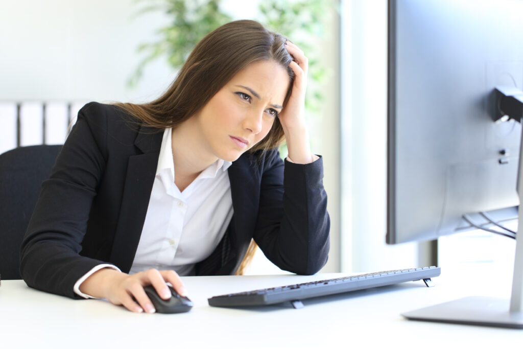 Woman working on computer annoyed reading about malicious compliance.